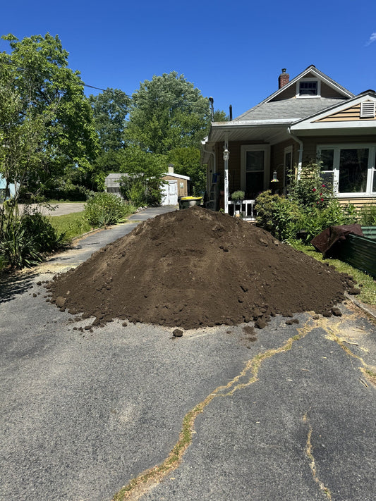 Six cubic yard pile of Common Borrow fill delivered to a residential driveway in Bellingham, Massachusetts for a raised vegetable garden build