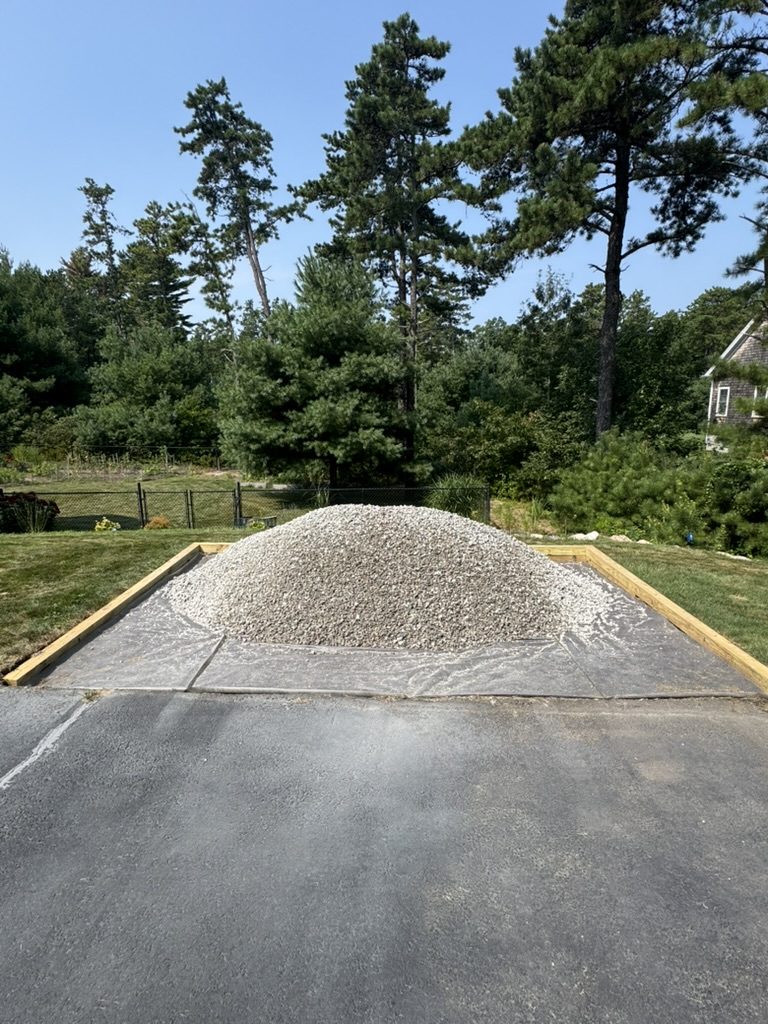 Bulk gravel dropped at the end of a driveway for rut repair