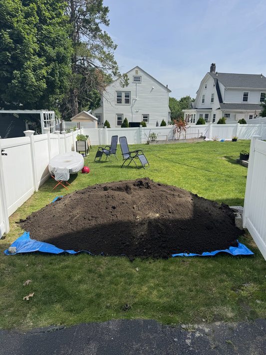 Two cubic yard pile of horticulture soil delivered directly into a residential backyard in Quincy, Massachusetts via dump truck