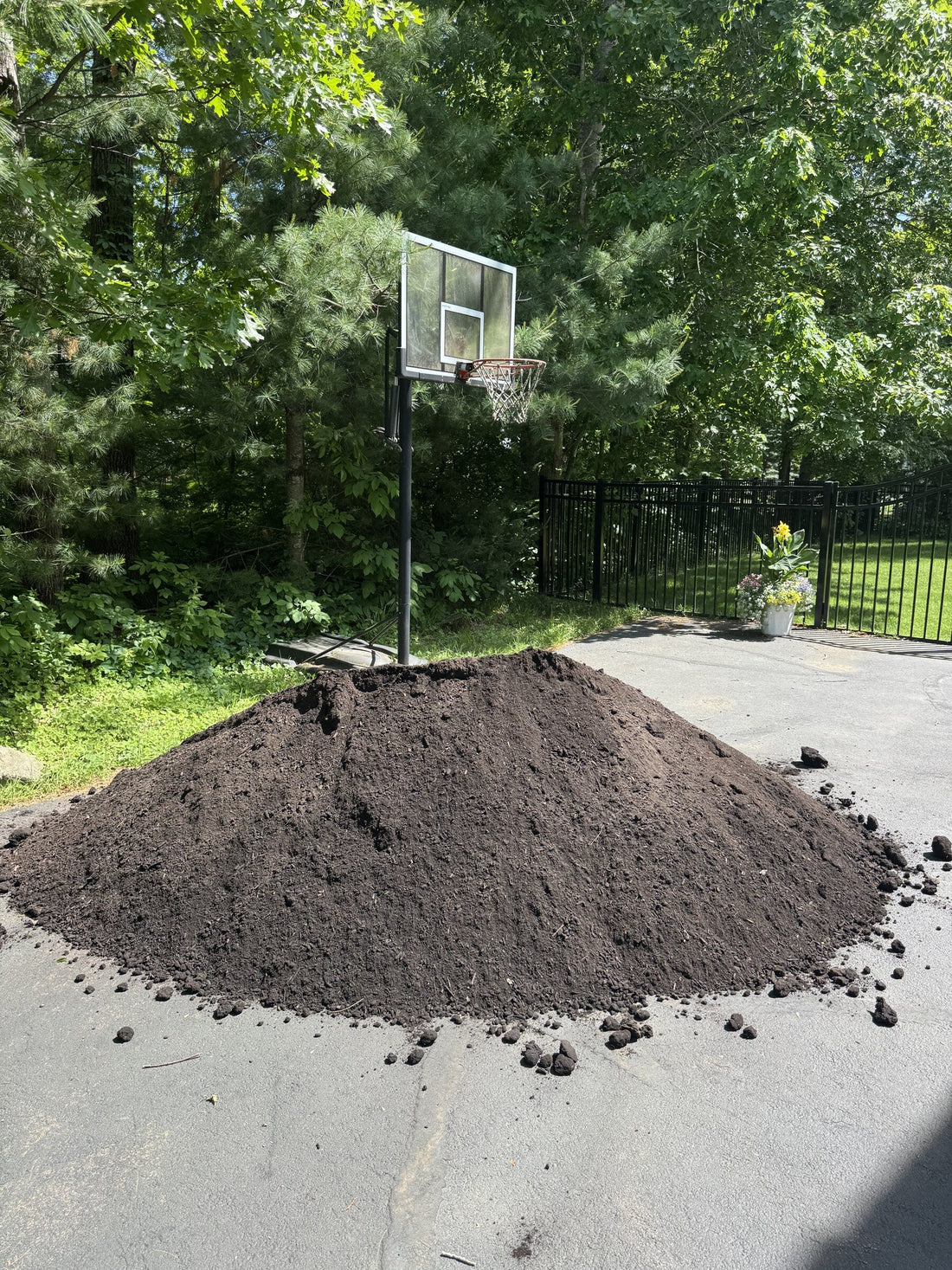 Pile of dark rich Super Loam screened topsoil delivered to a residential driveway in Merrimac, Massachusetts