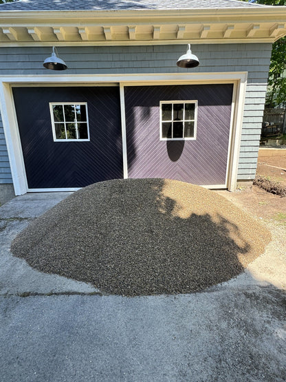 Three cubic yard pile of rice stone delivered to a residential driveway in Winchester, Massachusetts